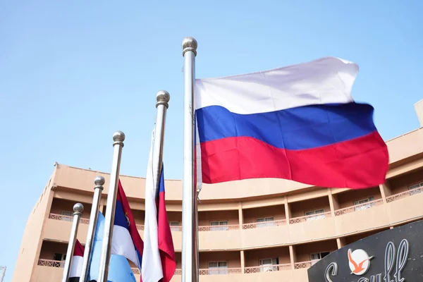 Mavi gökyüzü olan bir otelin önündeki diğer bayraklarla birlikte Rus bayrağı. Yüksek kalite fotoğraf