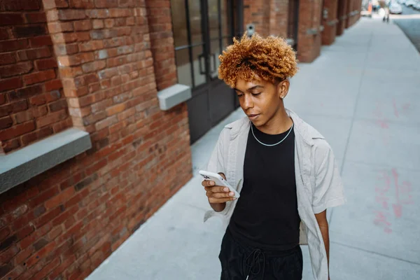 年轻的多种族男子 穿着时髦的衣服 在户外散步时手持智能手机 在城市街道上寻找有智能手机应用的地址 — 图库照片