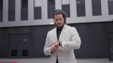 Ciddi yetişkin iş adamları modern ofis binasına gitmek için saatlerini kontrol ediyorlar. Akıllı patron sabah işe gidecek, kopya alanı olan bir panorama.