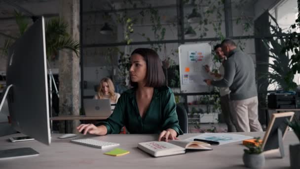 現代の同僚のオフィスに座って仕事のためにPcコンピュータを使用してスタイリッシュなシャツを身に着けている焦点を当てた白人女性 Brunetteオフィスの従業員は オープンスペースでキーボードを入力し 電子メールに答える — ストック動画