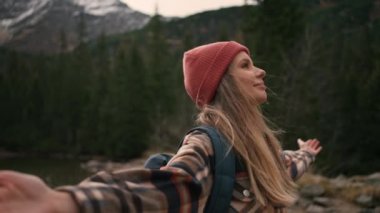 Young woman backpacker hiking in forest mountain while travel on summer holiday vacation trip. Attractive girl traveler enjoy outdoor lifestyle and spreading arms while feeling freedom