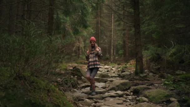金发活泼的女人在树林里走来走去 踩着岩石 享受大自然 业余爱好 娱乐时间概念 — 图库视频影像