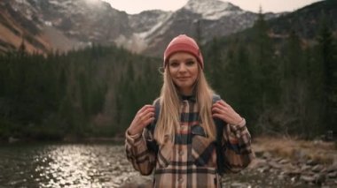 Euphoric pretty woman with tourist backpack walking alone through wild nature enjoying hiking adventure alone. Travelling and tourism concept