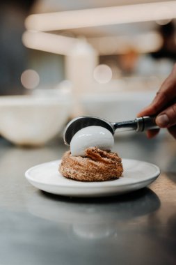 Vertical view of the unknown chief hand decorating cake at the restaurant. Pastry chef making sweet dessert cake concept
