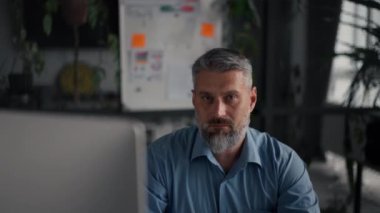 Bilgisayarda çalışan kıdemli bir iş adamı ve çağdaş ofiste kameraya gülümsüyor. Son sınıf öğrencisi işyerinde rahat bir sandalyede oturuyor.