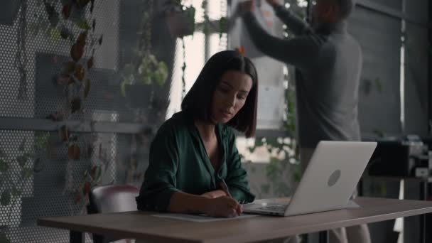 Serious Brunette Businesswoman Wearing Green Shirt Writing Notes Looking Laptop — Video Stock