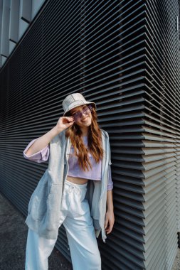 Spor giyimli modaya uygun beyaz kız dansçı sokak dansı hareketini sergiliyor. Neşeli yaz kadın sanatçısı şehirde koreografi gösterisi yapıyor. Yüksek kalite fotoğraf