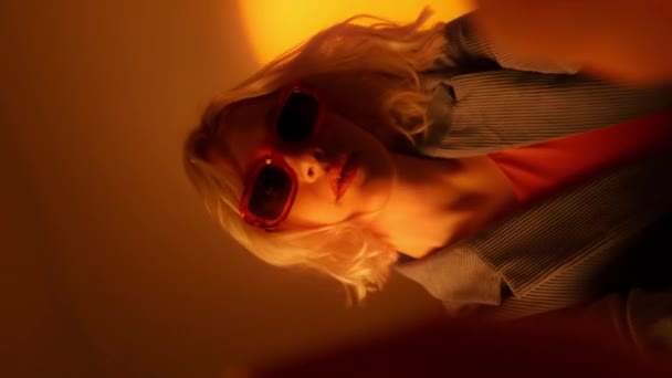 Turuncu Arka Planda Izole Edilmiş Güneş Gözlüklü Sarışın Kadın Portresi — Stok video