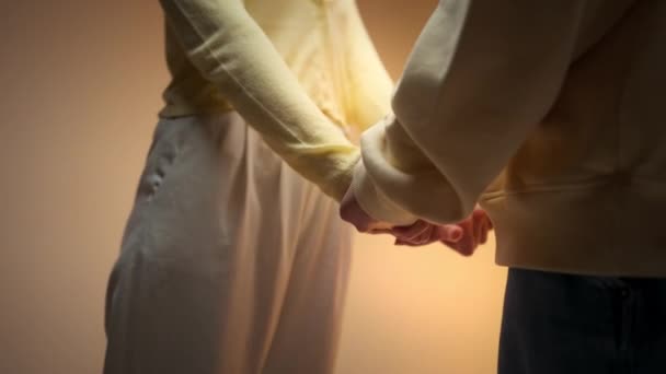 両手だ ベージュのスタジオの背景に手を触れる明るい色の服を着た男と女のクロップビュー 官能的な概念 — ストック動画