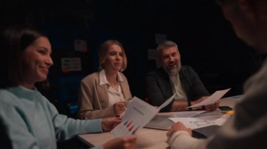 Rüya takım. Kendine güvenen iş adamları, birlikte beyin fırtınası yapıyorlar, akşam toplantısı boyunca modern ofis alanında yeni bir proje üzerinde çalışıyorlar.