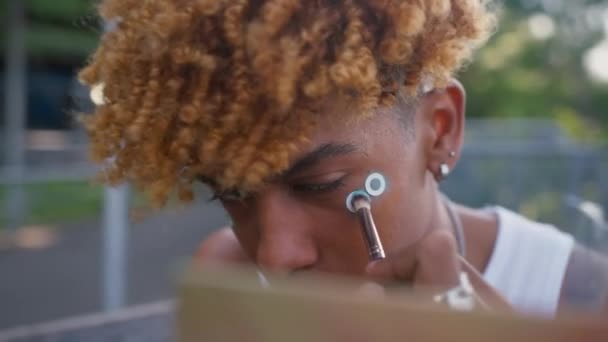 Atento Adolescente Afroamericano Sosteniendo Cepillo Preparando Maquillaje Calle Mientras Mira — Vídeo de stock