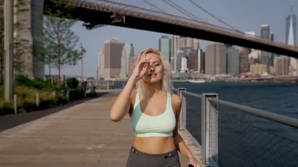 Blondynka Stroju Fitness Słuchawkach Przebiegająca Przez Brzeg Rzeki Bieganiu Świeżym — Wideo stockowe