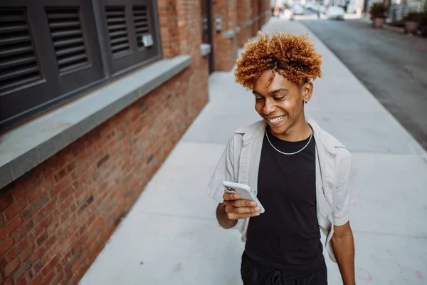 多种族学生在城市街道上边走边用智能手机 专心致志的男人与朋友聊天 — 图库照片