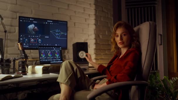 松懈的女性游戏开发者使用她的个人电脑和笔记本电脑在创造性的办公空间进行设计工作 微笑的女士看着相机 — 图库视频影像