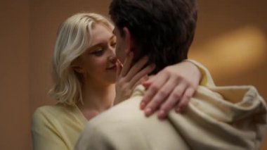 Güzel sarışın kadın, mutlu bir çift olarak sevgilerini gösteren çekici bir erkeğe nazikçe dokunur. Birlikte anın tadını çıkarıyorlar..