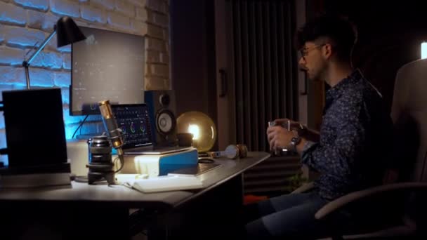 Genç Stüdyo Yapımcısı Tatilden Sonra Ofise Giriyor Kulaklık Takıyor Bilgisayarda — Stok video