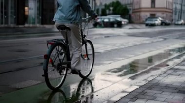 Akşam kentinde bisiklete binen genç bir kadının yakın görüntüsü. Aktif kız yazın bisiklet kullanıyor. Çevre dostu ulaşım konsepti