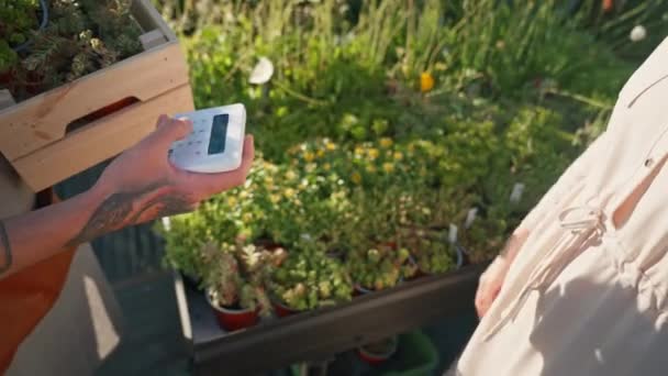 花屋の女性はスマートフォンで支払っています お金の取引 モバイル決済 高品質の写真 — ストック動画