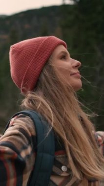 Young woman backpacker hiking in forest mountain while travel on summer holiday vacation trip. Attractive girl traveler enjoy outdoor lifestyle and spreading arms while feeling freedom