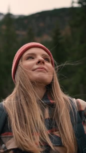 金发女游客凝视着高山和湖泊 带着帽子和背包的白人女孩一个人欣赏风景 旅行概念 — 图库视频影像