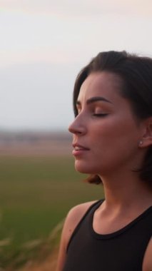 Calm woman enjoying free time for yoga practice and making breath exercises. Attractive female with closed eyes feeling good during zen research and asanas