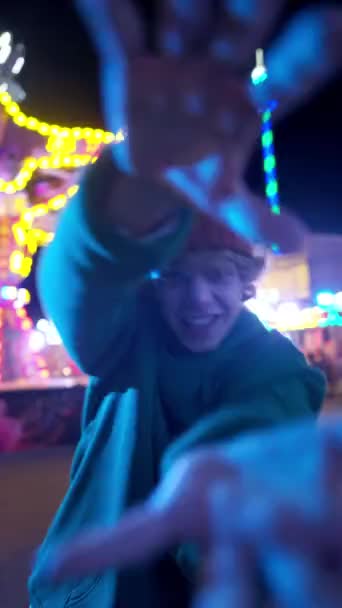 在狂欢节公园里 穿着超大的帽衫 旋转着相机 跳着舞的快乐少年的垂直视图 现代生活方式概念 — 图库视频影像