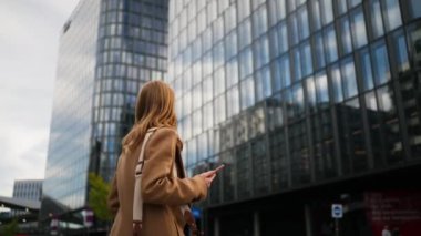 Sokakta telefonu kullanan başarılı bir iş kadını. Ciddi bir iş kadını dışarıda telefonla dolaşıyor. Sokakta telefonla mesajlaşan genç bir kadın. Akıllı telefon ile çalışan kadın girişimci. 