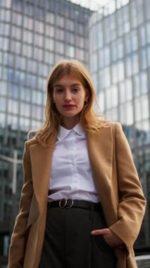 Şehir merkezinde poz veren kadın portre yöneticisinin dikey görüntüsü. Modern binada takım elbiseyle poz veren mutlu bir ofis çalışanı. Neşeli iş kadını, kameraya bak, tatilin tadını çıkar. Kendine güvenen başarılı.