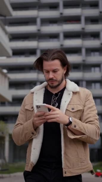 年轻的欧洲人走在秋天的城市街道上 商人拿着手机 打电话 技术和人的概念 — 图库视频影像