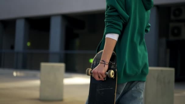 Gedeeltelijk Uitzicht Tiener Skateboarder Die Skateboard Vasthoudt Tijdens Het Wandelen — Stockvideo