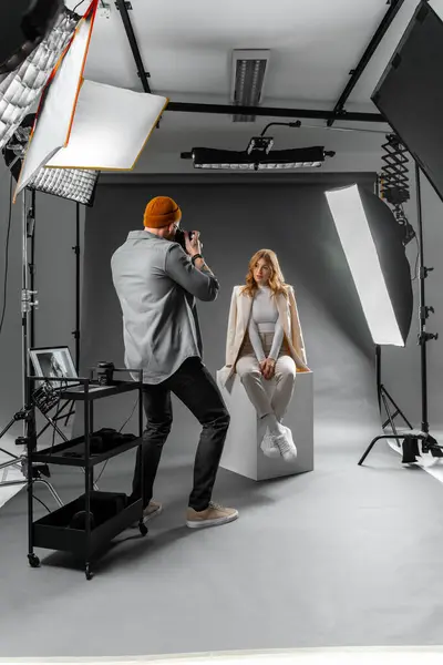 Photographer and fashion model in studio for creative art, clothes brand and designer social media blog. Digital photography, light equipment and people with photoshoot innovation ideas