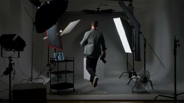 Fokussierter Männlicher Fotograf Justiert Beleuchtungsausrüstung Für Fotoshooting Studio Mit Schwarzem Videoclip