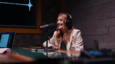Stüdyoda fotokopi alanı olan neşeli genç bir kadın podcast yapıyor. Kulaklık ve mikrofonlu kendine güvenen bir kadın evde podcast kaydediyor. Mutlu kız internet radyosunda konuşuyor.