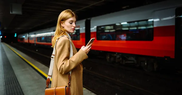 Vakava Liikenainen Puku Surffata Langaton Internet Älypuhelimella Metrossa Nainen Seisoo — kuvapankkivalokuva