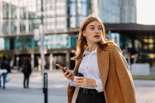 Elegante Kvinnelige Entreprenør Leser Økonomiske Nyheter Telefon Mens Passerer Crosswalk – stockfoto