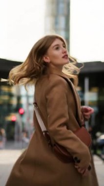 Lüks bir iş kadınının varış noktasını ve işletme bölgesini ararken dikey bir bakış açısı. Portre muhteşem emlakçı sokakta geziniyor ve kameraya bakıyor.