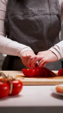 Tahta tahtada taze domates doğrayan genç bir kadının elleri İtalyan makarnasını sebze ve kıyma ile hazırlarken