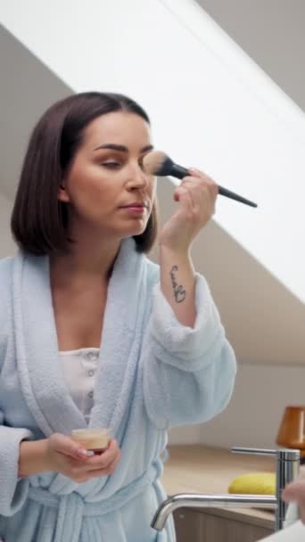 Uma Mulher Roupão Banho Está Cuidadosamente Aplicando Maquiagem Seu Rosto — Vídeo de Stock