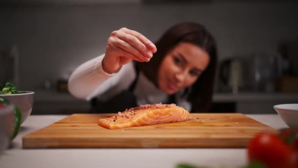 Brunette Woman Apron Salting Fresh Raw Salmon Wooden Board Table — Stock Video