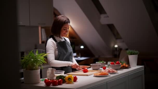 面带微笑的千禧年妇女站在厨房里烹调健康的素食的画像 苗条健康的女士在家为午餐准备蔬菜沙拉 — 图库视频影像