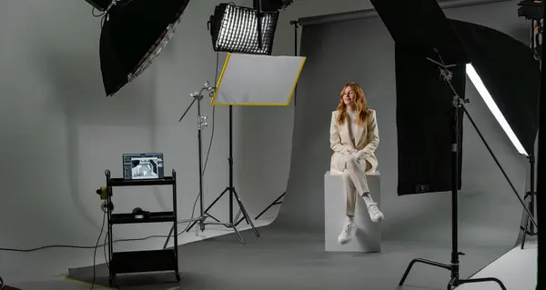 プロの機器を備えた写真スタジオで金髪の若い女性モデル 舞台コンセプトを背景にした制作 ロイヤリティフリーのストック写真