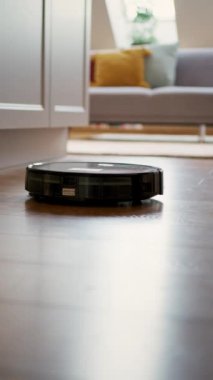 Robot elektrikli süpürge, oturma odasındaki ahşap zemini gelişmiş alet teknolojisiyle etkin bir şekilde temizliyor.