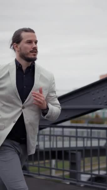 スマートビジネスマン街の通りを実行している 会議のために遅くまで勤務している 都市部の橋でスーツジョギングで成功した男 急いで任命に男 — ストック動画