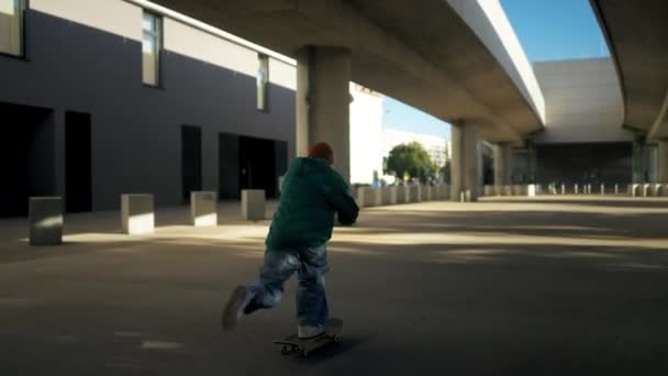 都市駐車場での男性スケートボーダーのトレーニング 実行トリックを準備する都市服の男 — ストック動画
