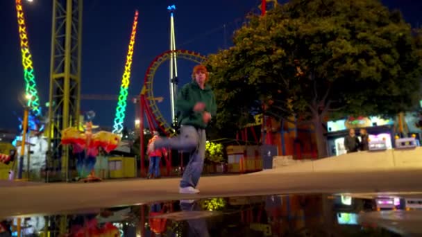 全景的时髦的欧洲裔家伙有一个有趣的跳舞 在户外自由泳 感情用事的人在游乐园里享乐 — 图库视频影像
