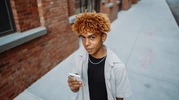 Молодий Чоловік Завитими Волоссям Джери Стоїть Тротуарі Зачарований Його Мобільним Стокове Зображення