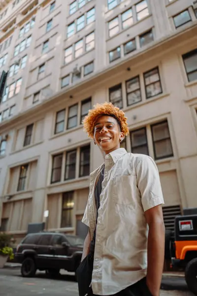 Ein Junger Mann Mit Perücke Steht Vor Einem Wuchtigen Gebäude Stockfoto