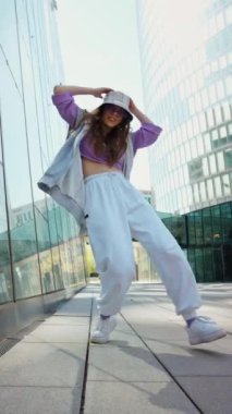 Spor giyimli modaya uygun beyaz kız dansçı sokak dansı hareketini sergiliyor. Neşeli yaz kadın sanatçısı şehirde koreografi gösterisi yapıyor. Yüksek kalite 4k görüntü