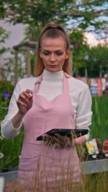 Bahçe merkezinde kadın işçi. Tablet kullanıyorum. Bahçıvan. Yüksek kalite fotoğraf