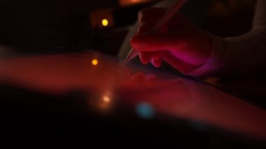 Kadın ressam ressamın yeşil ekran dijital tabletine çizdiği resimlerin kırpılmış görüntüsü. Stylus ve neon ışığı. Yaşam tarzı yaratıcı hobi ve serbest sanatsal çalışma kavramı
